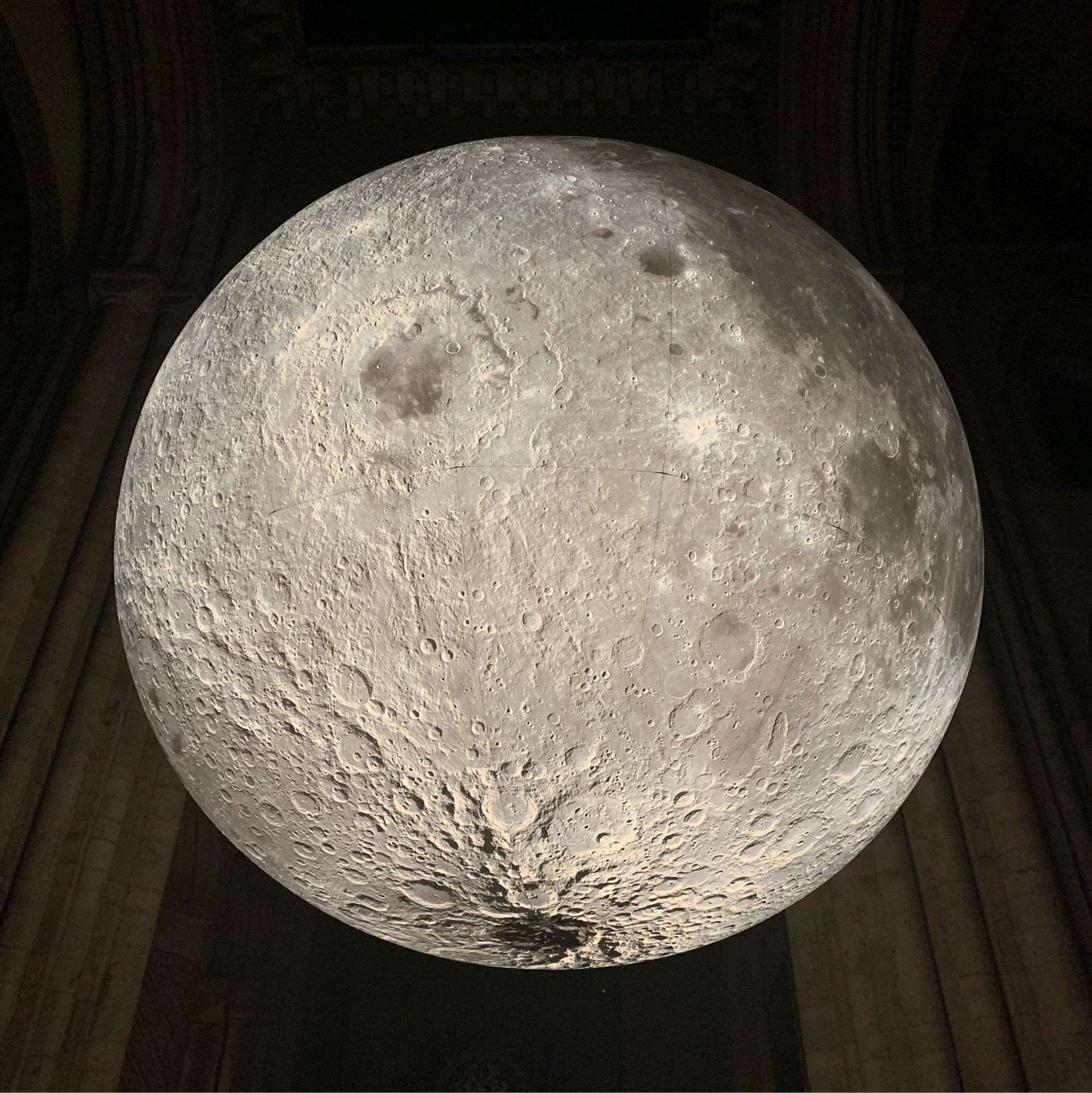 Illuminated inflatable moon suspended above the altar of Durham Cathedral
